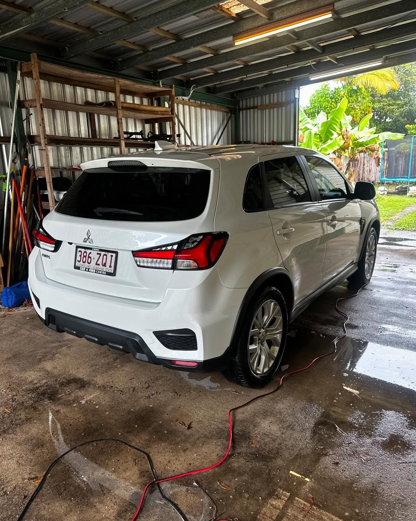 White Mitsubishi SUV parked in a garage with wet floor – Mobile Club Cars Cairns in Earlville, QLD
