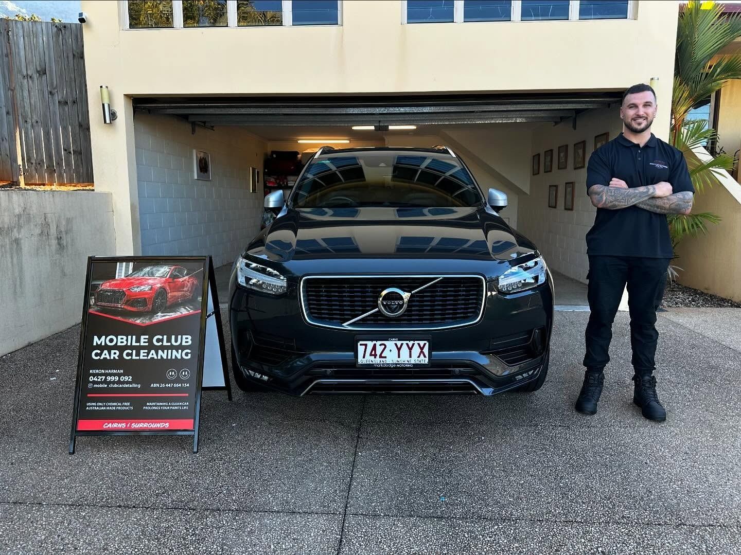 A Man Stands Beside a Black Volvo SUV in a Garage — Mobile Club Cars Cairns in Earlville, QLD