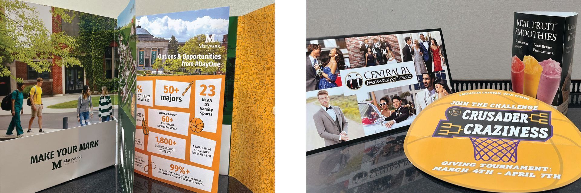 Outdoor display of colorful event posters and banners with a crowd scene and a large “Craziness” sign
