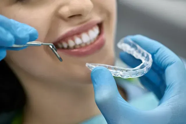 Une femme se fait blanchir les dents par un dentiste.