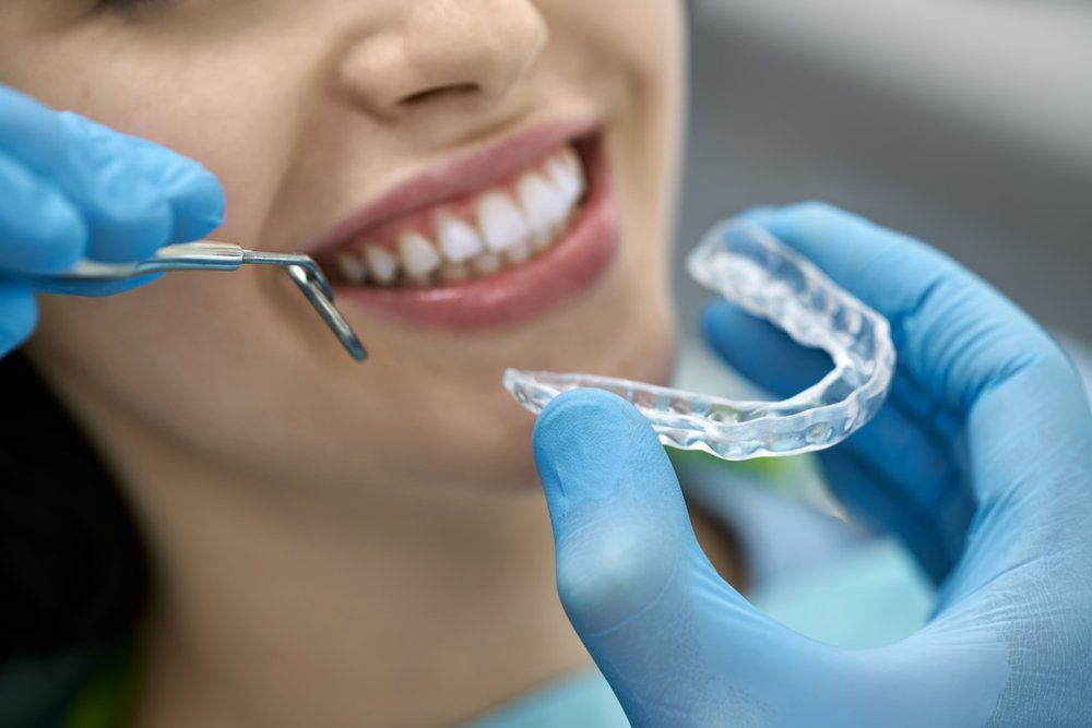 Une femme se fait blanchir les dents par un dentiste.