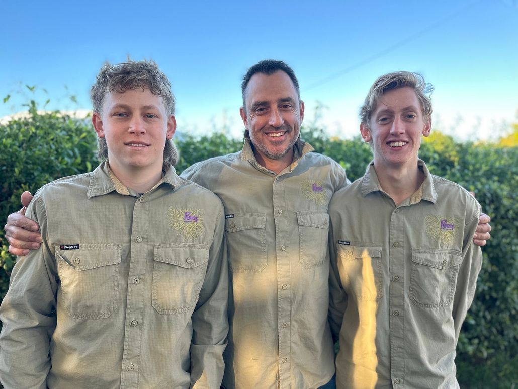 Three men in khaki shirts are posing for a picture together.