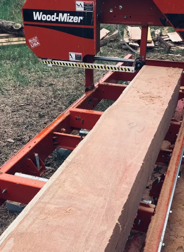 A wood mizer is cutting a piece of wood