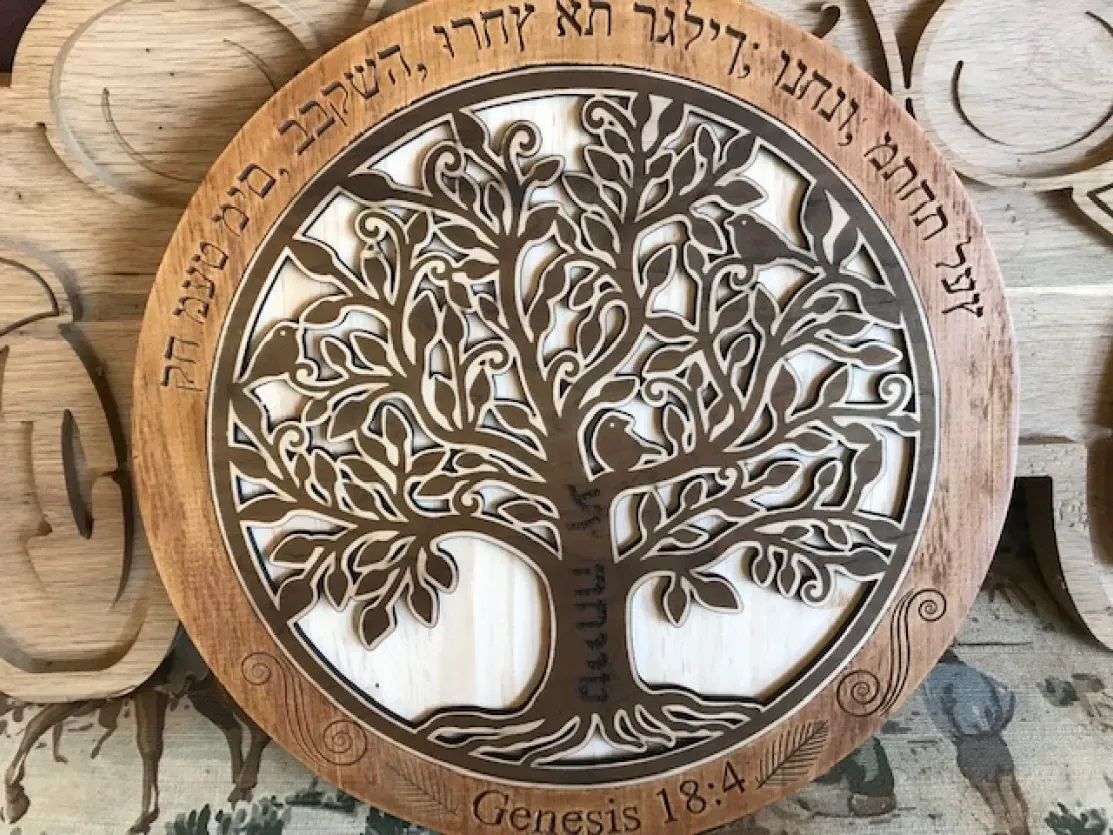 A wooden plaque with a tree of life on it