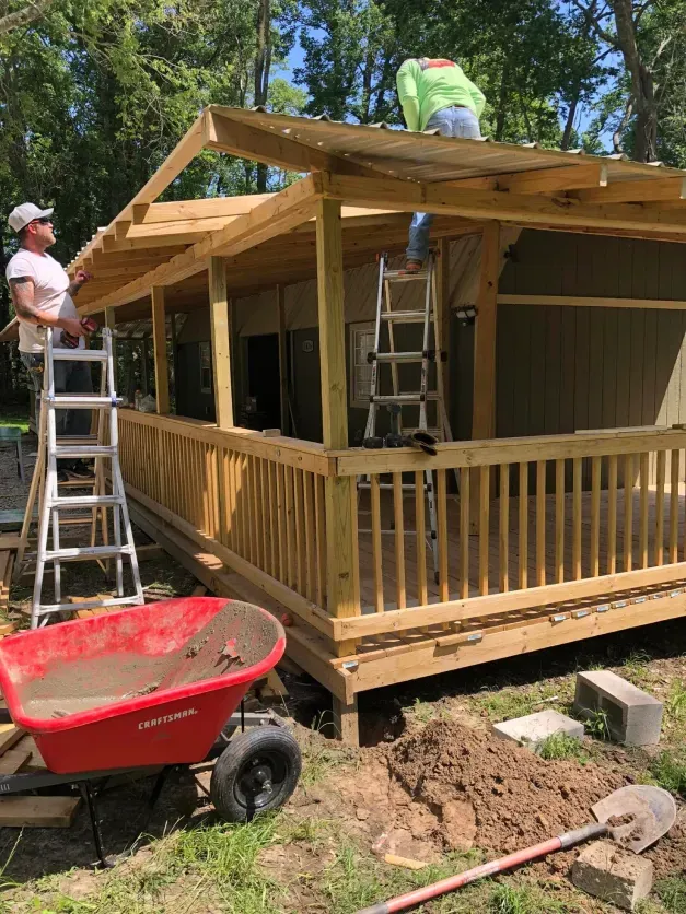 A man is working on the roof of a wooden house.
