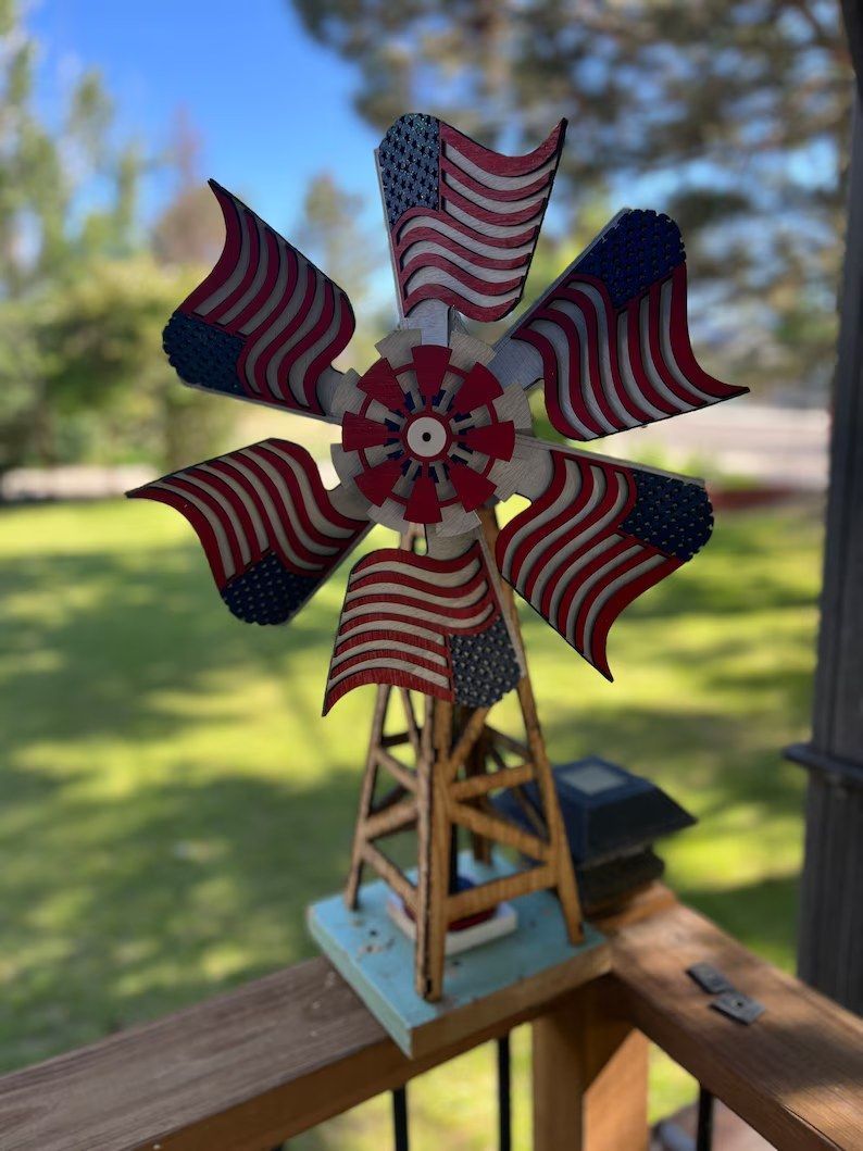 A windmill with american flags on it is on a deck