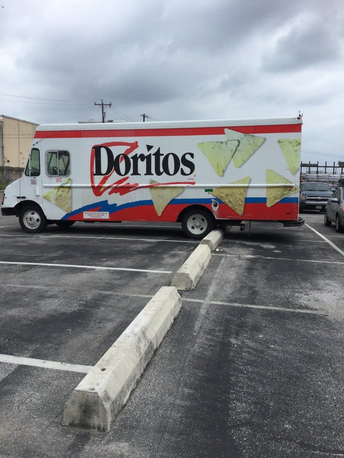 Large Truck Parked in Front of Car Wheel Stop