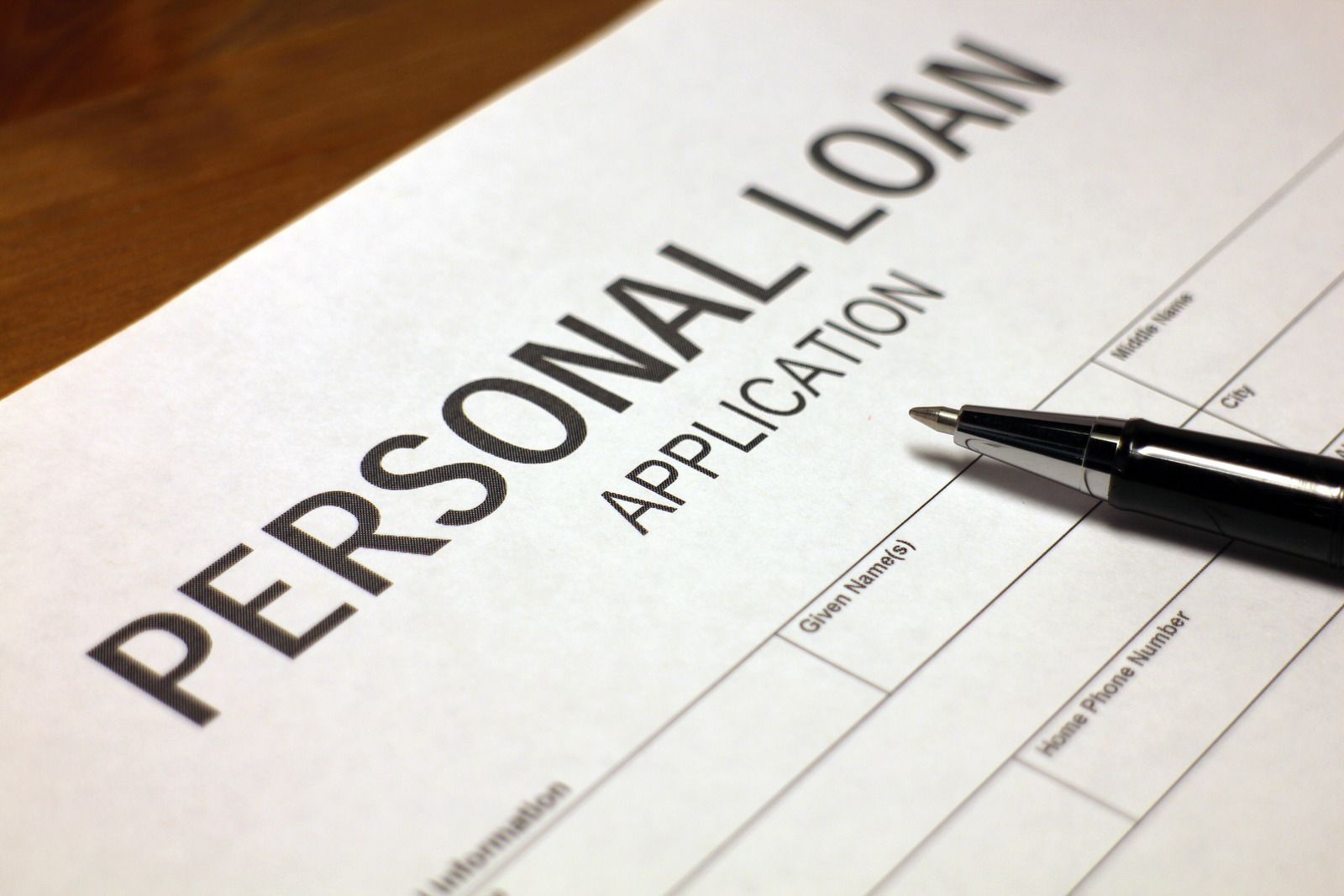 Personal loan application form on a desk with bold black text and blank fields