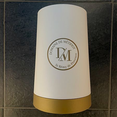 Een witte en gouden cilinder met de letter m erop