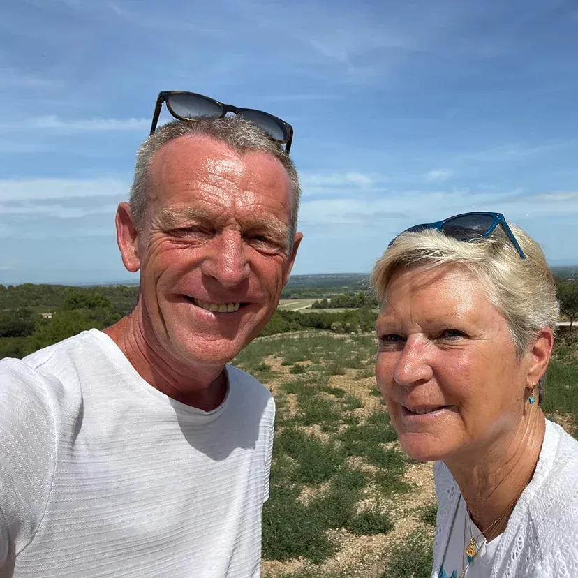 Een man en een vrouw poseren voor een selfie in een veld.