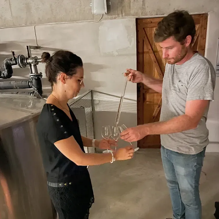 Een man en een vrouw staan ​​naast elkaar met wijnglazen in hun handen