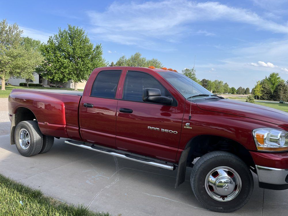 A red dodge ram truck is parked on the side of the road.