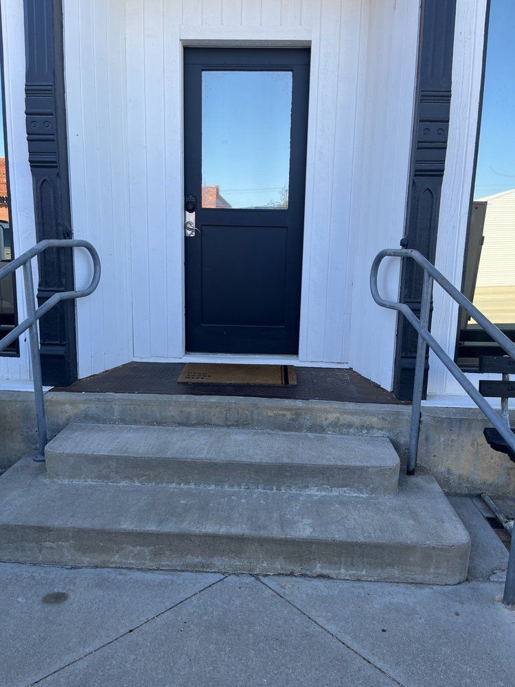 The front door of a building with stairs leading up to it.
