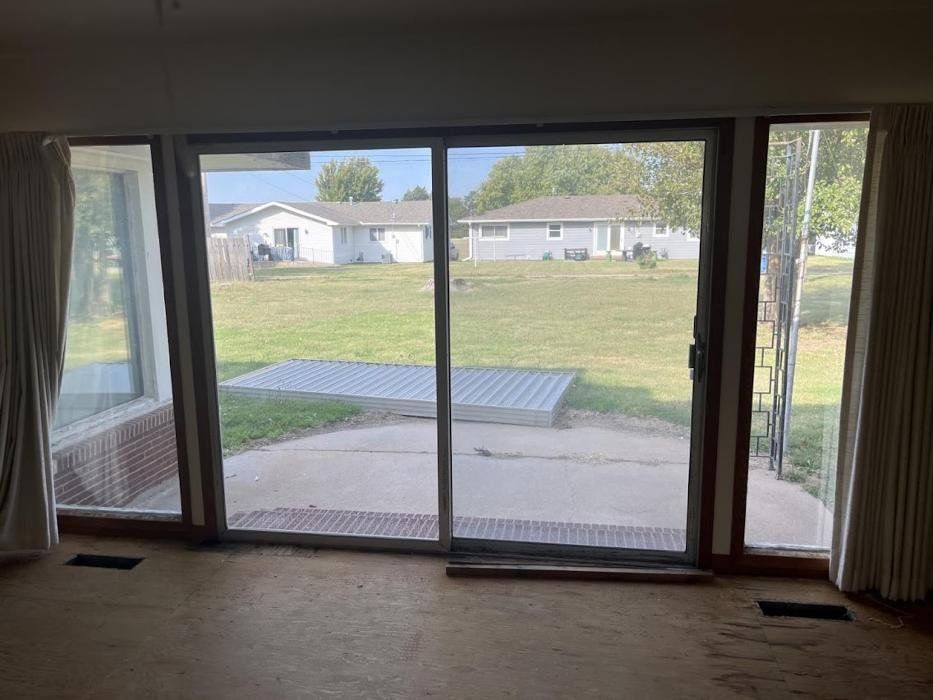 A living room with a sliding glass door leading to a backyard.