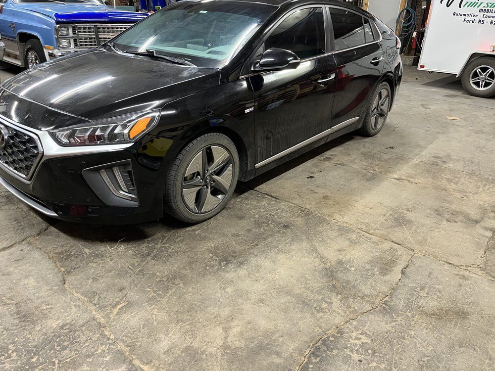 A black hyundai ioniq is parked in a garage.