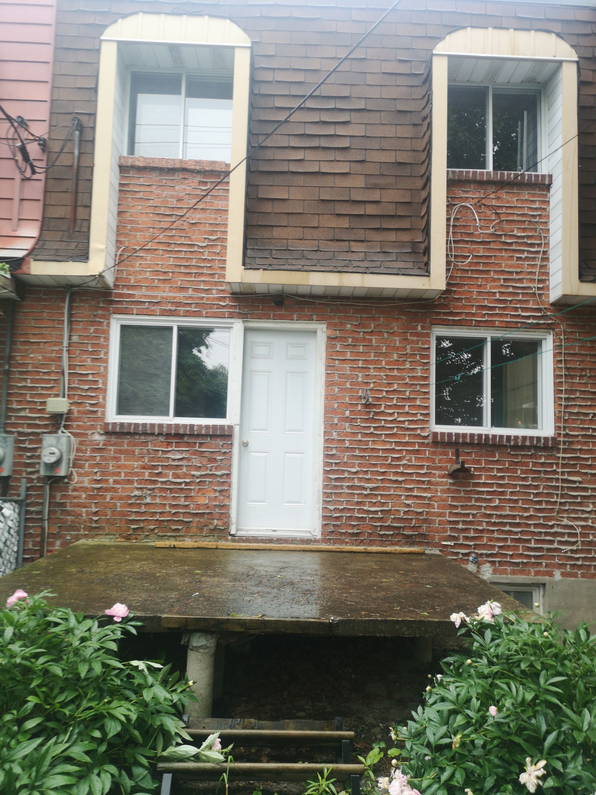 Un bâtiment en brique avec une porte et des fenêtres blanches