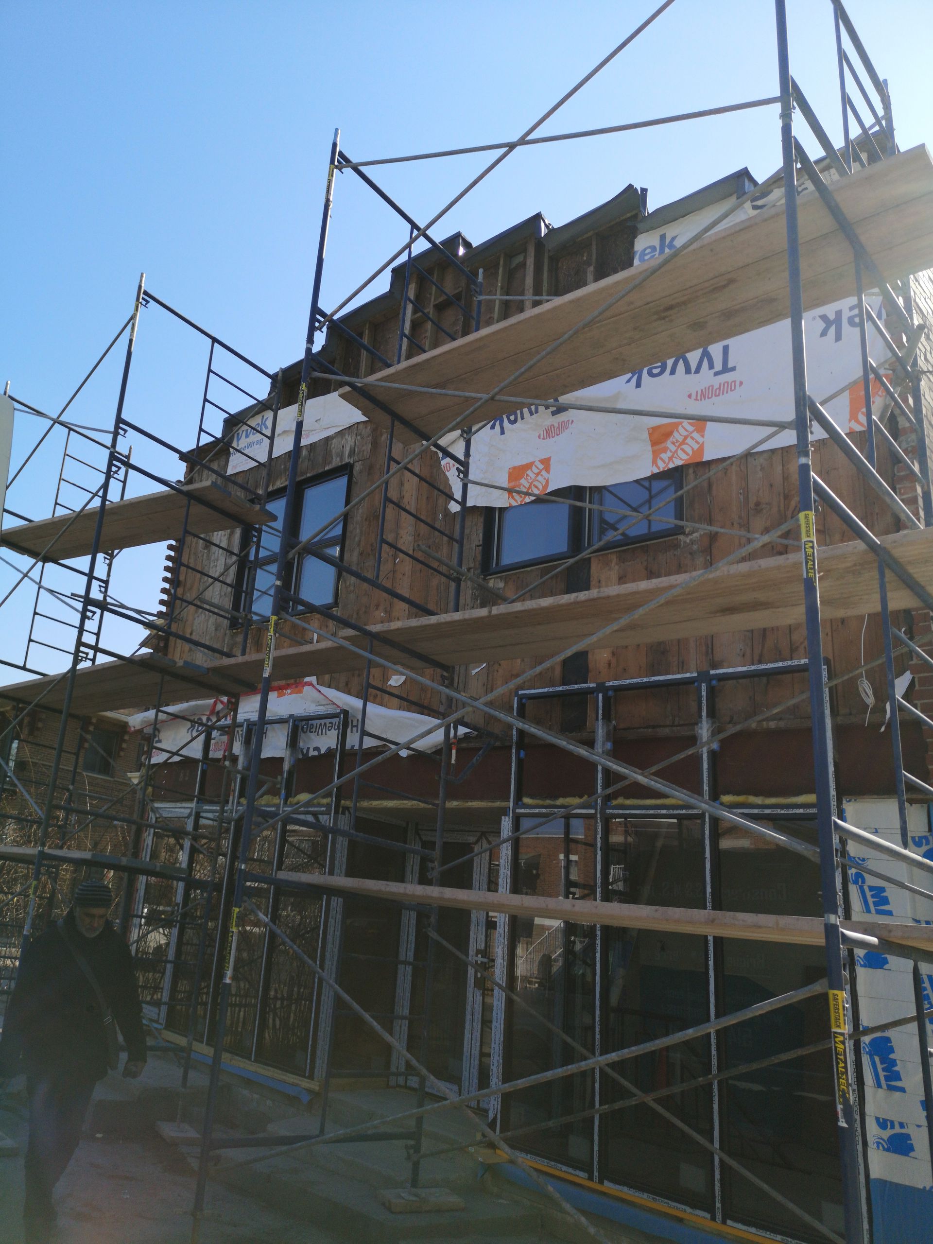 Une maison est en construction avec des échafaudages sur le côté