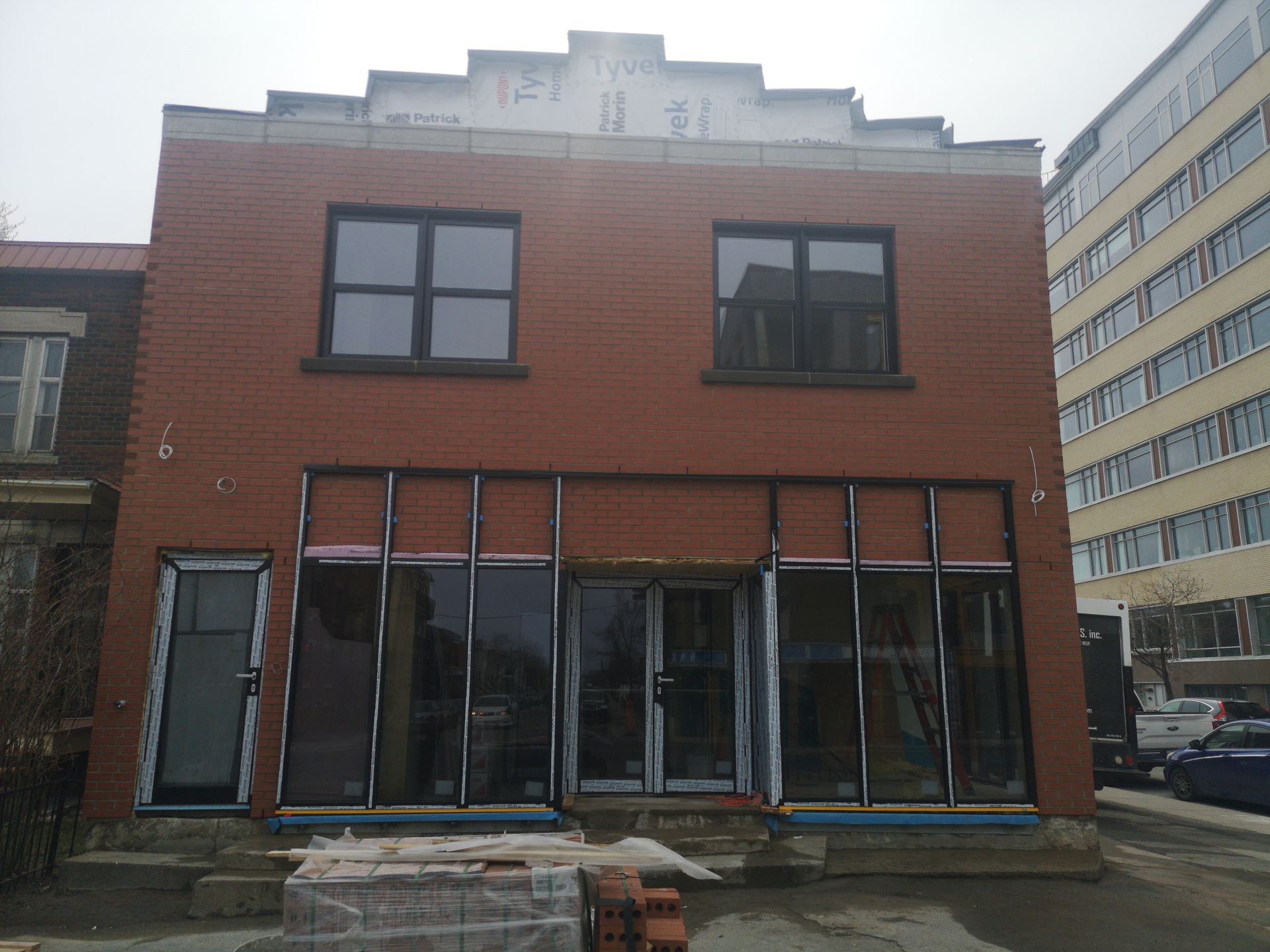 Un bâtiment en brique avec de nombreuses fenêtres est en construction.