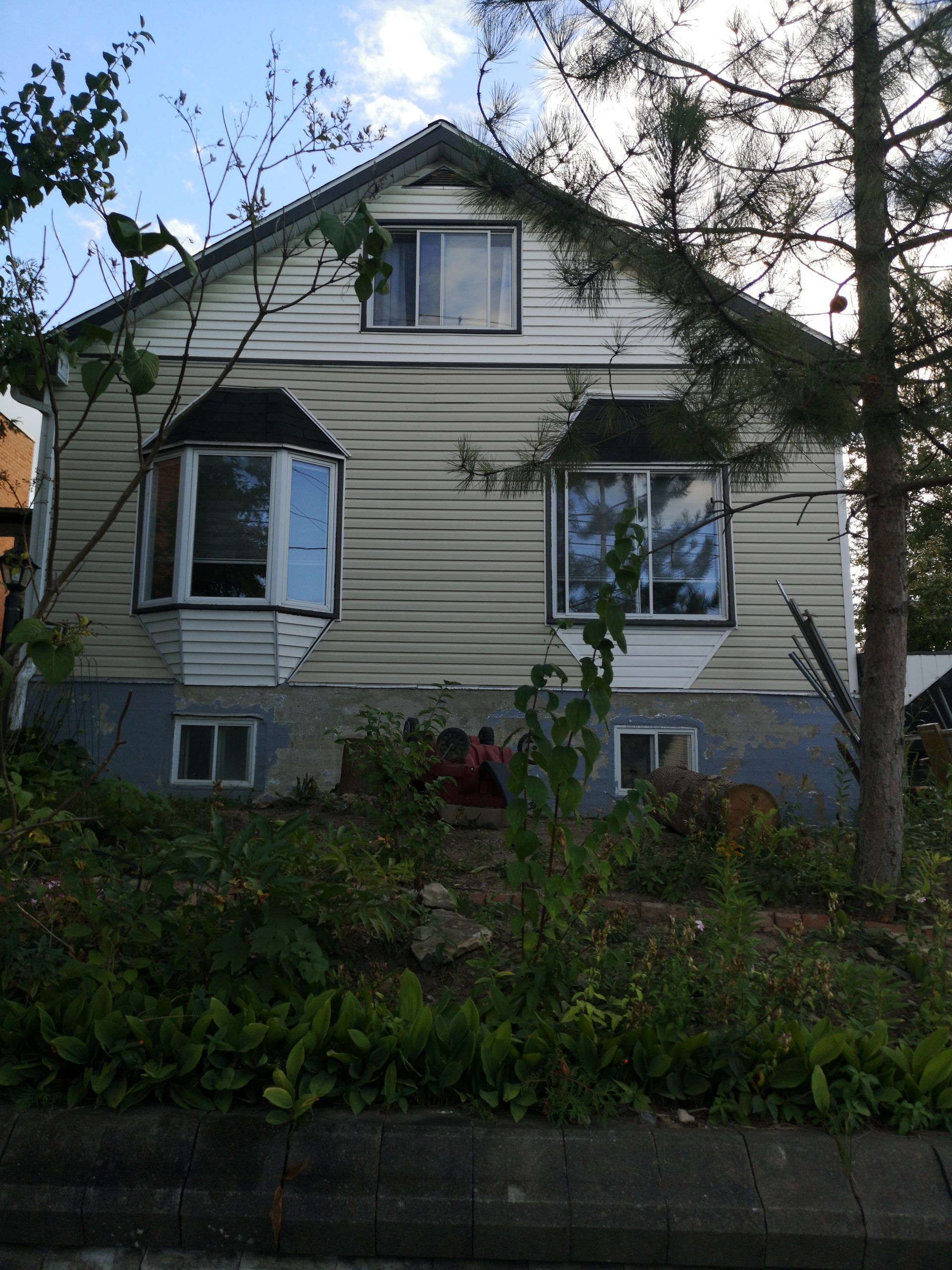 Une maison avec beaucoup de fenêtres et des arbres devant