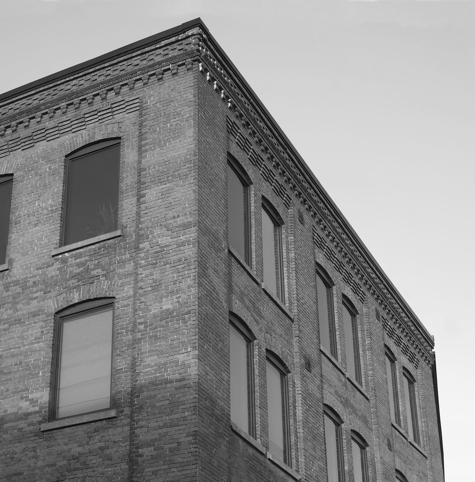 Bâtiment en briques avec de nombreuses fenêtres sous un ciel dégagé.