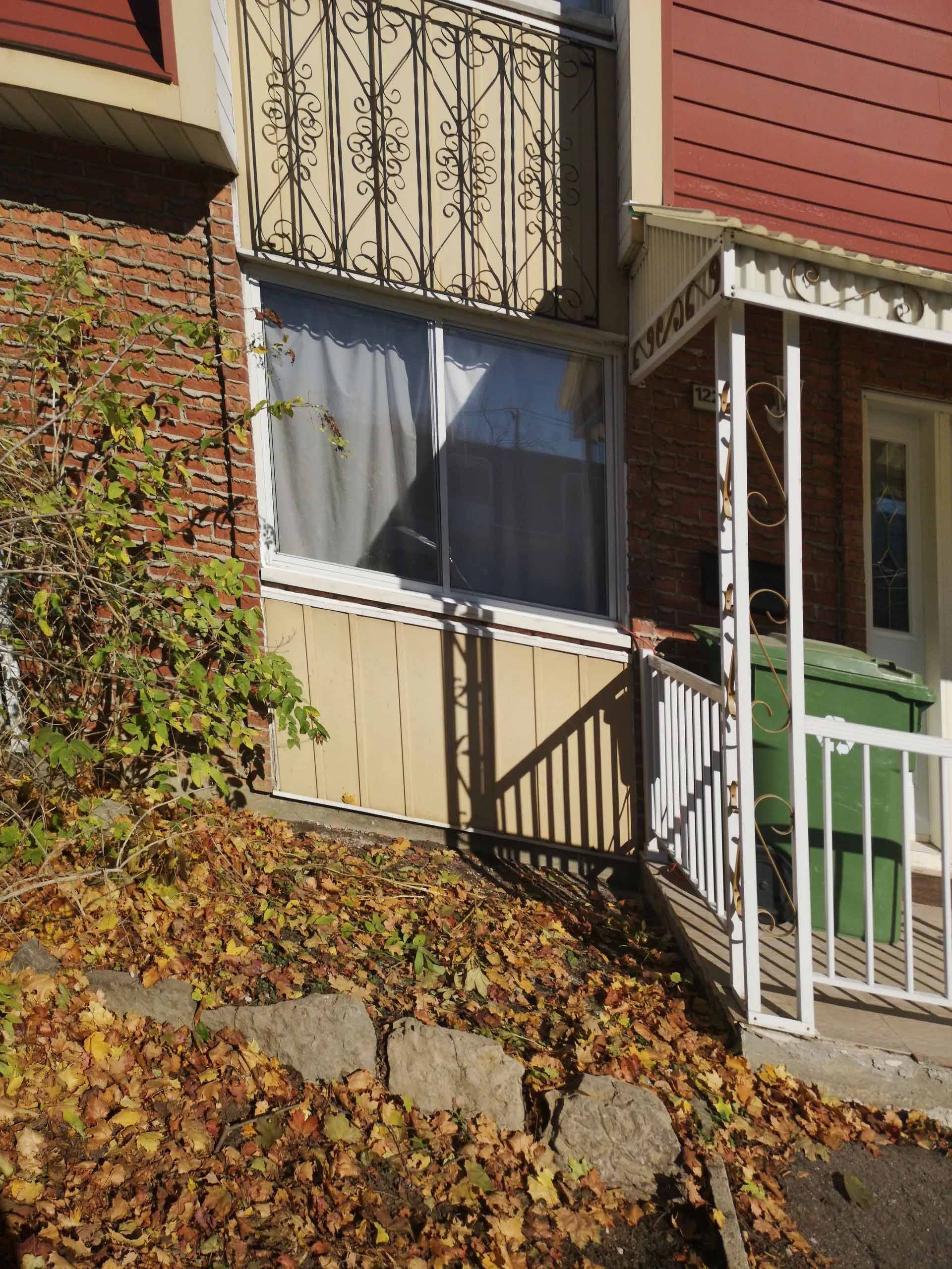 Une maison en brique avec un porche et des escaliers qui y mènent