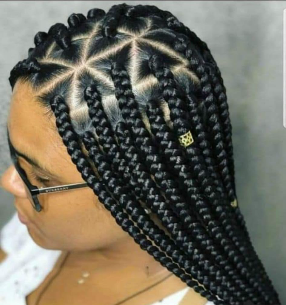 A woman with braids in her hair is wearing a blue shirt.