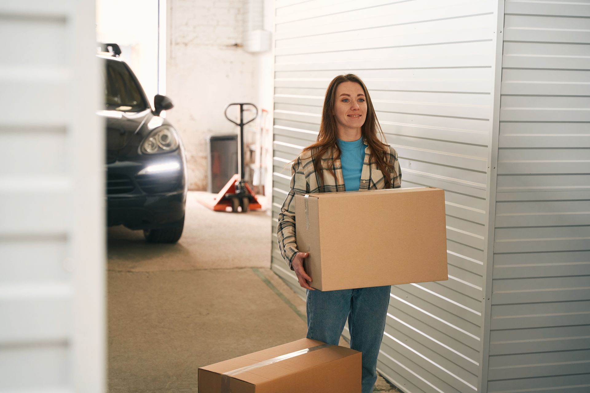 A woman is carrying a box into a storage unit