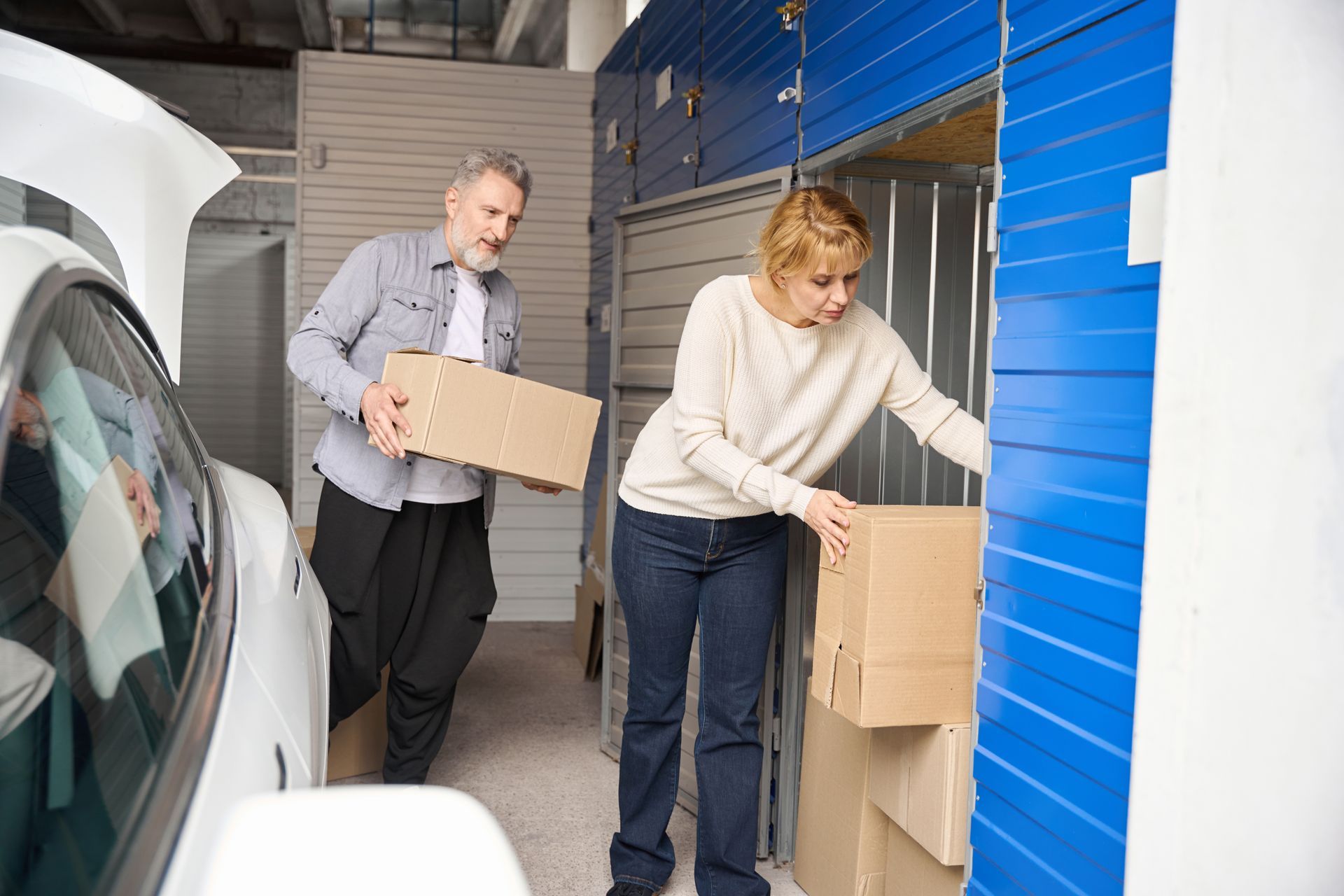 A couple is putting boxes in a self-storage unit.