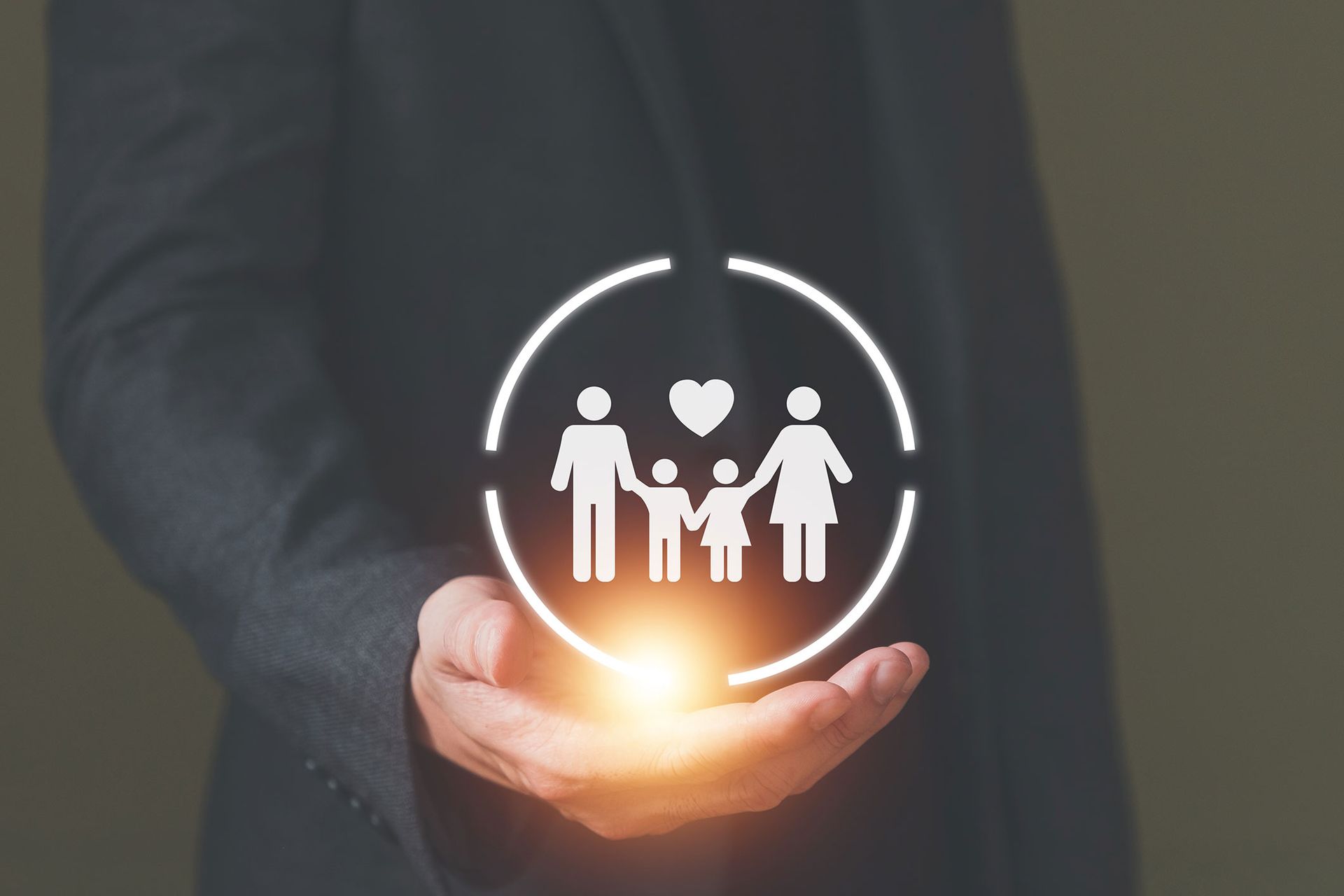Person holding a glowing family icon within a circle, symbolizing family protection.