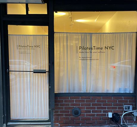 A store front with a sign that says pilates time nyc