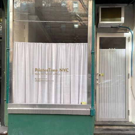 A store front with a sign that says pilates time nyc