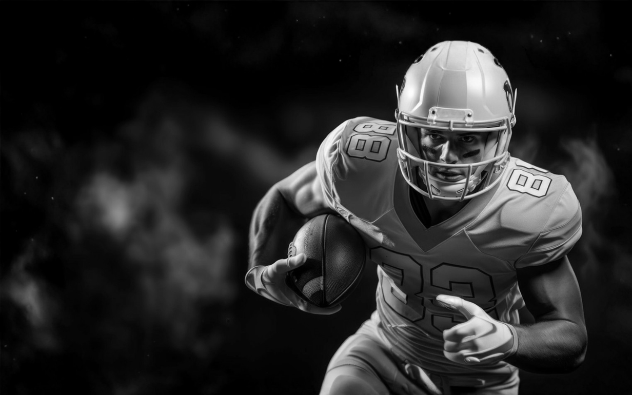 Football players in action on a grassy field; one runs with the ball, pursued by two opponents.