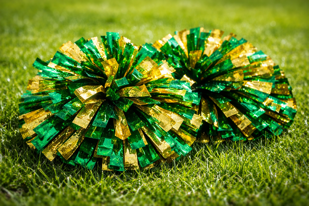 Red, white, and blue pom-poms held high by cheerleaders during a performance.