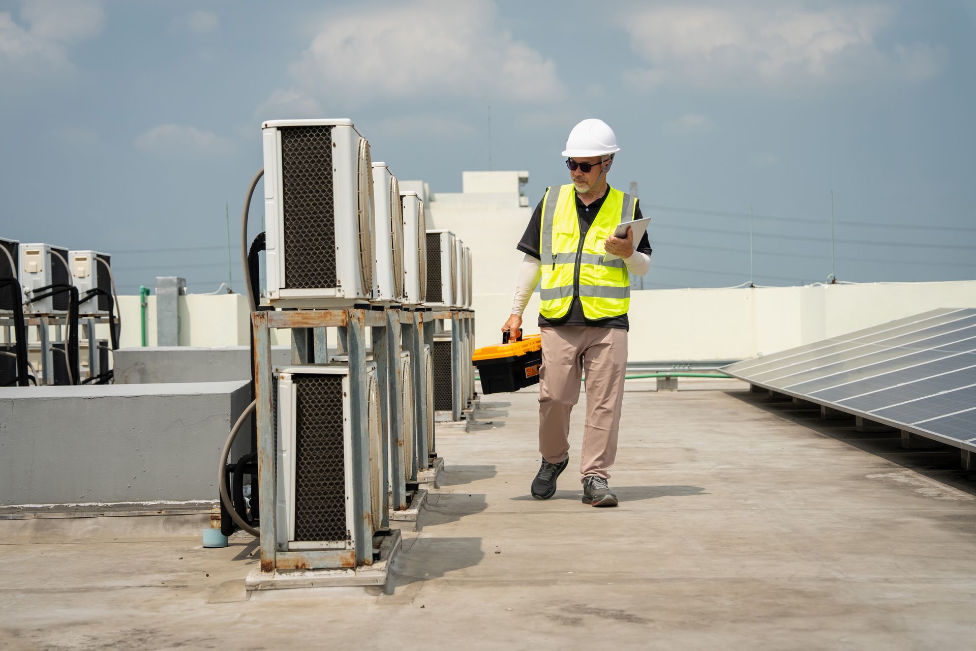 Commercial HVAC technician servicing rooftop heating and cooling equipment.