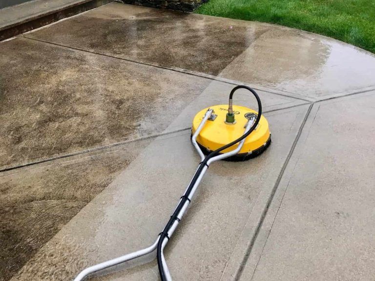 A yellow machine is sitting on top of a concrete patio.