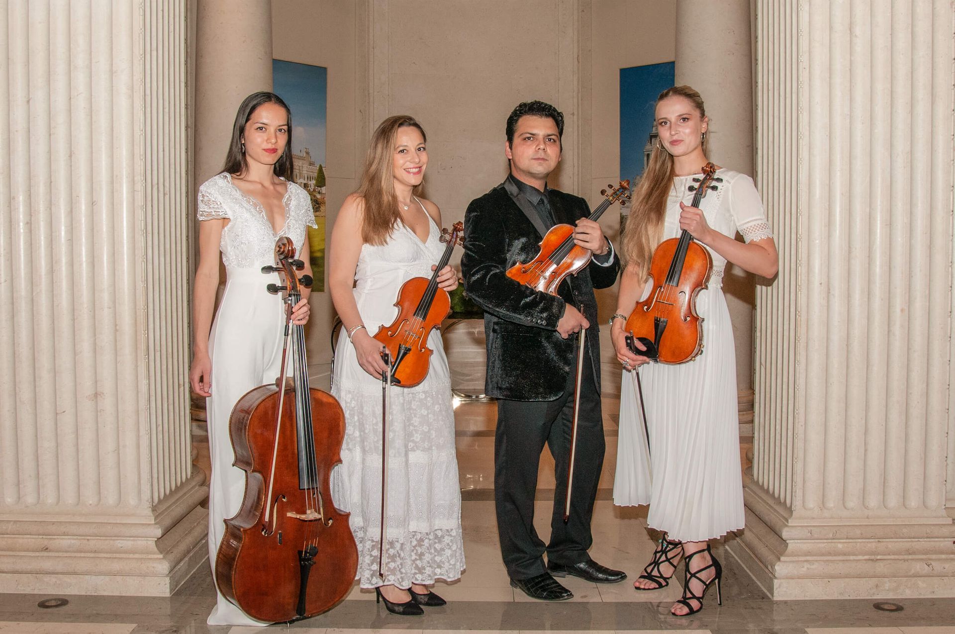String quartet, formal attire, holding instruments, standing in a classical-style setting.