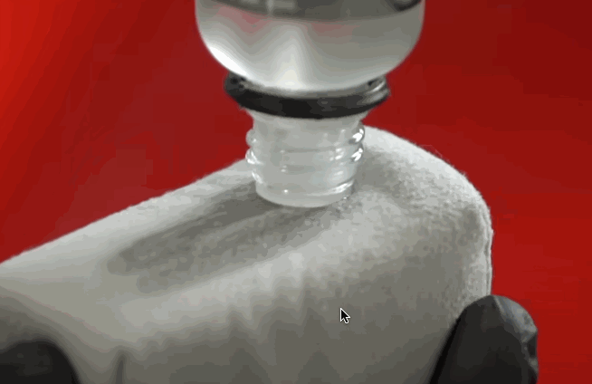 Close-up of a hand applying ceramic coating liquid to a microfiber cloth, ready for use on a car surface.