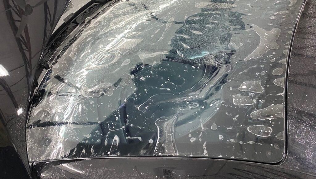 A close up of a car windshield covered in water.