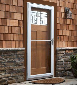 A wooden door with a white frame is on a brick wall