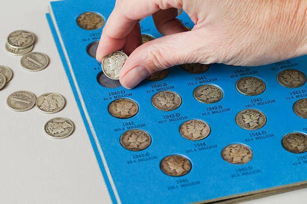 A person is putting a coin into a coin collection