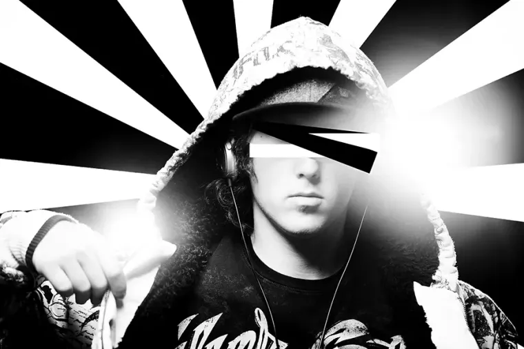 Black-and-white portrait of a hooded person with a bright radial burst background