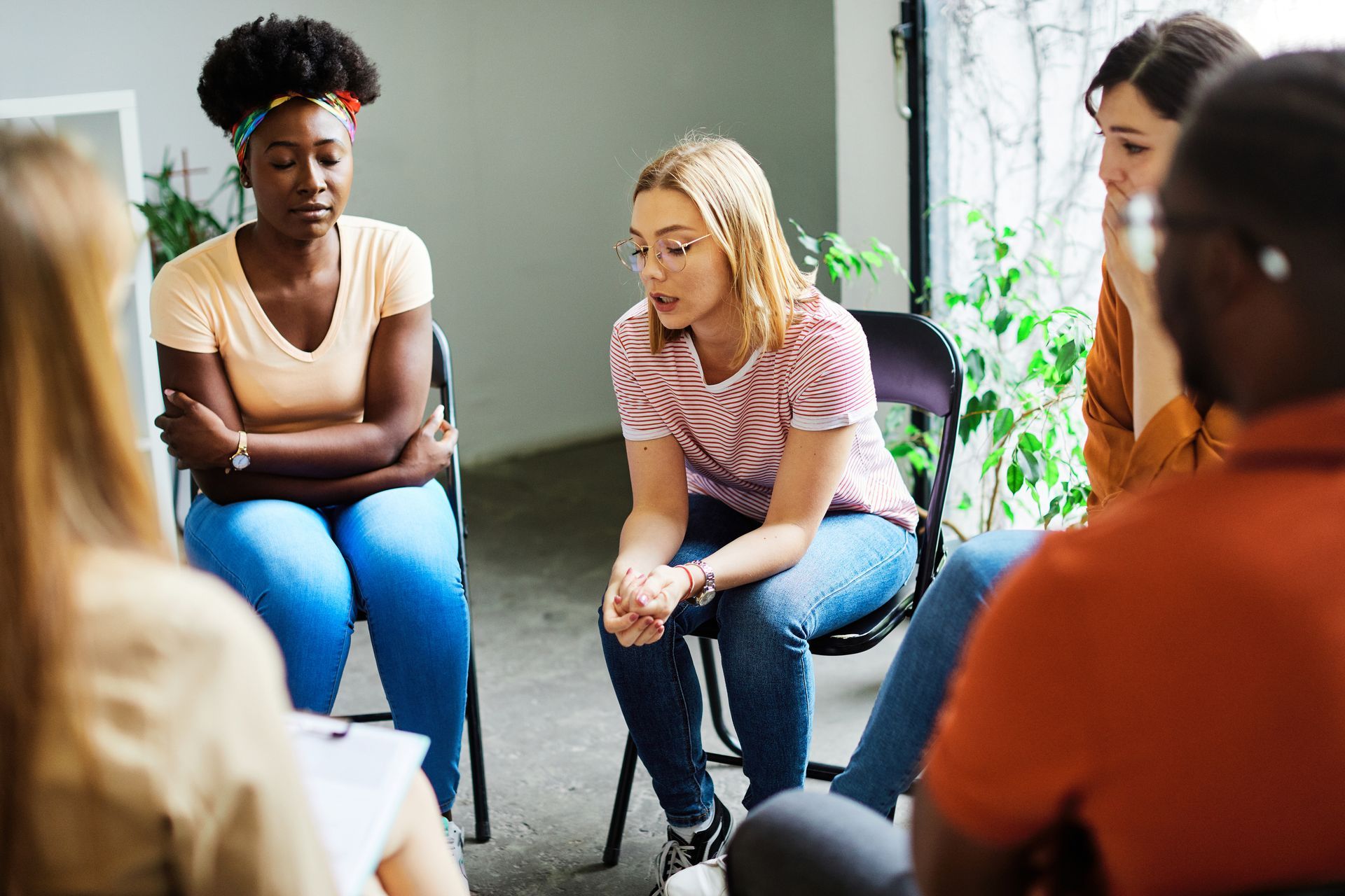 A group of people are sitting in a circle having a conversation.