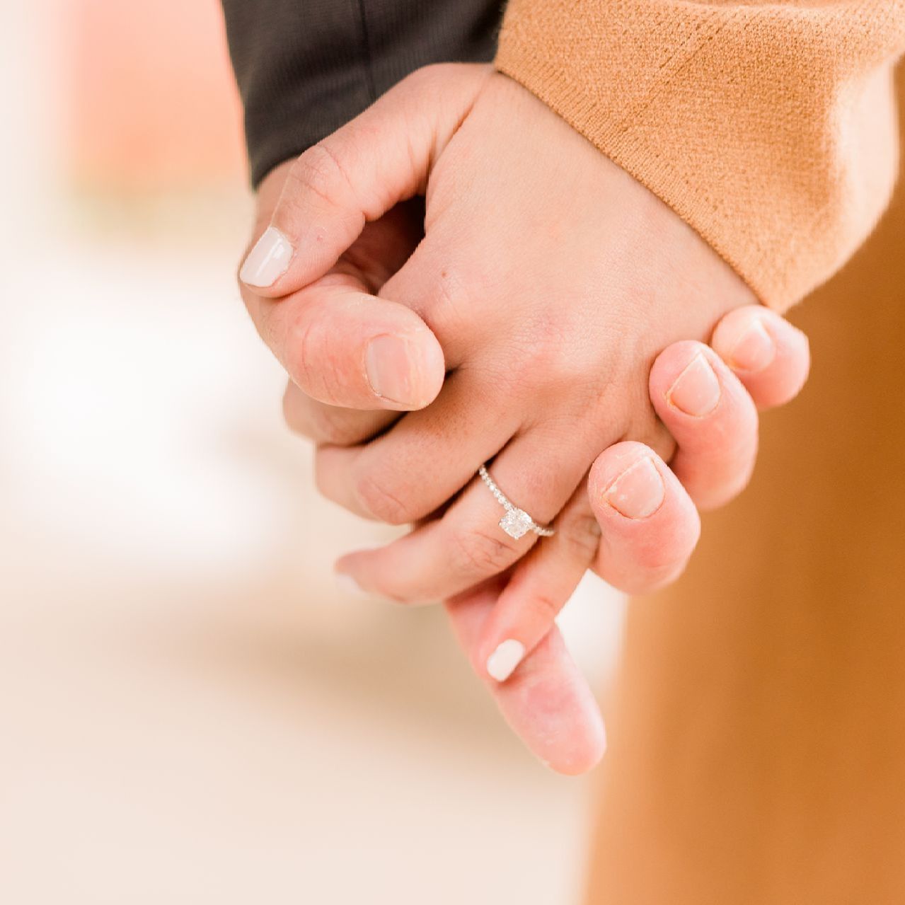 A close up of a person holding another person 's hand with a ring on their finger.