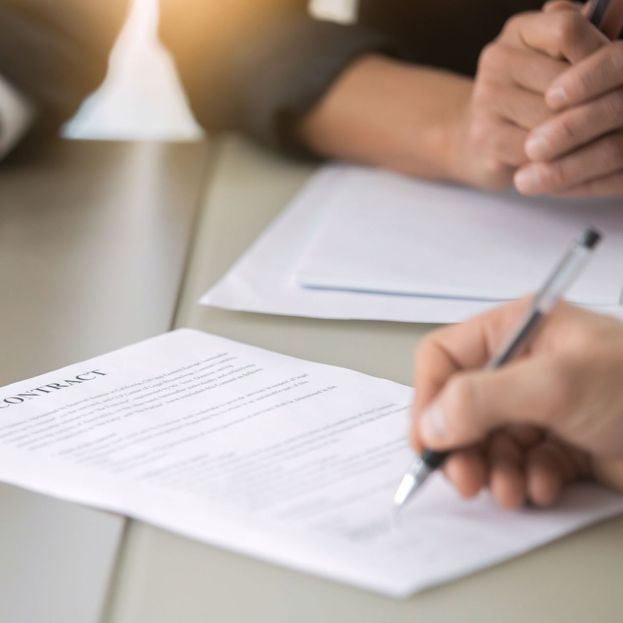 A person is writing on a piece of paper with a pen.