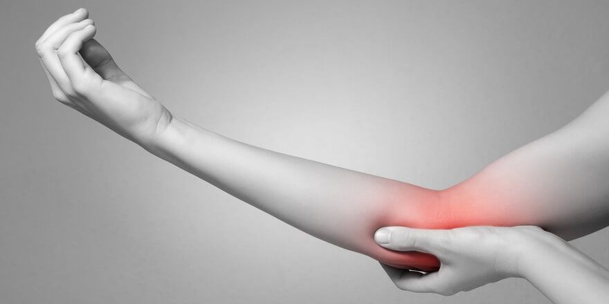 A person is holding their elbow in pain.