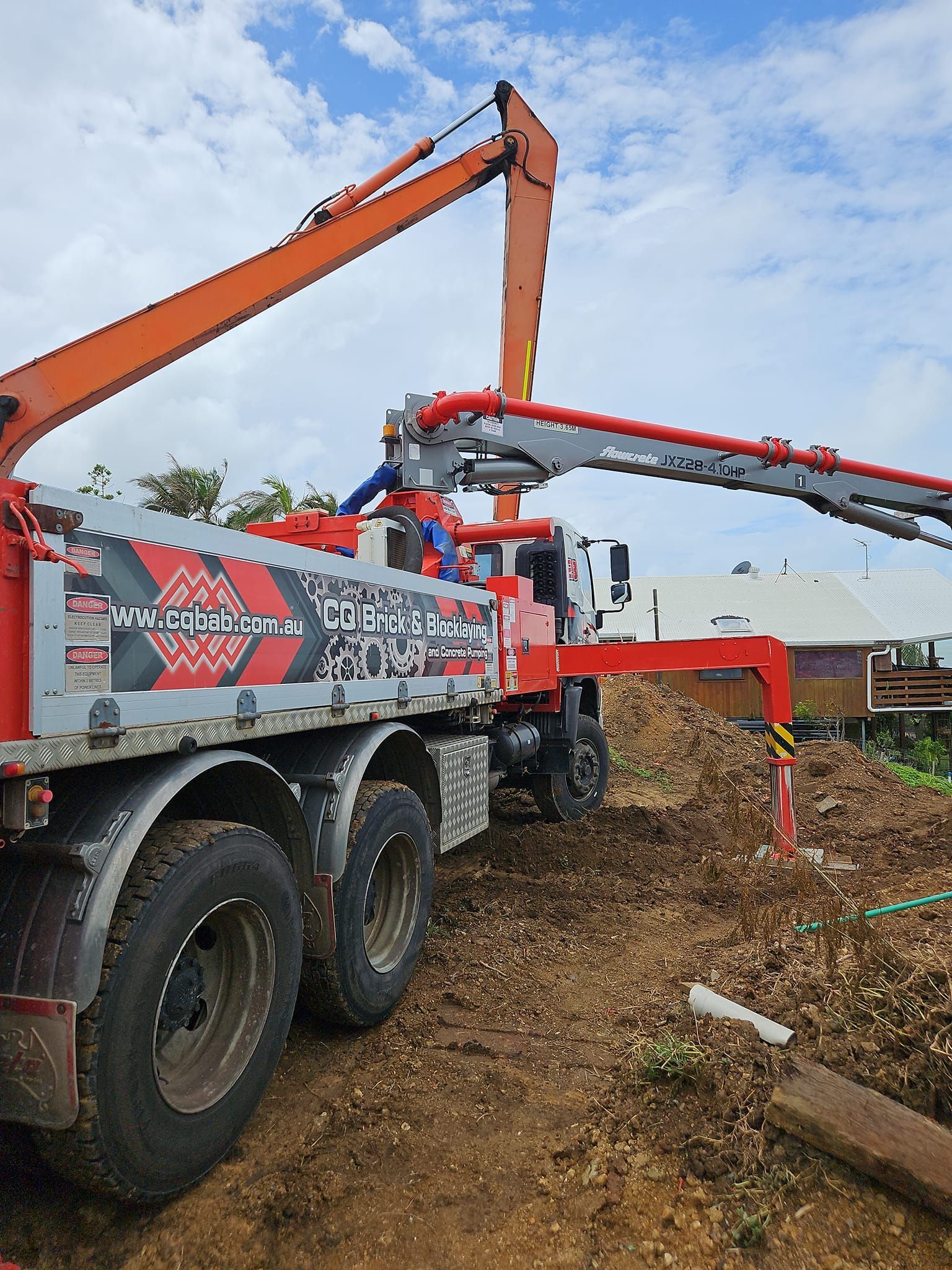 A Concrete Pump Is Being Used To Pour Concrete Into A Pile Of Bricks — CQBB Concreting Pumping Pty Ltd In Barmaryee, QLD