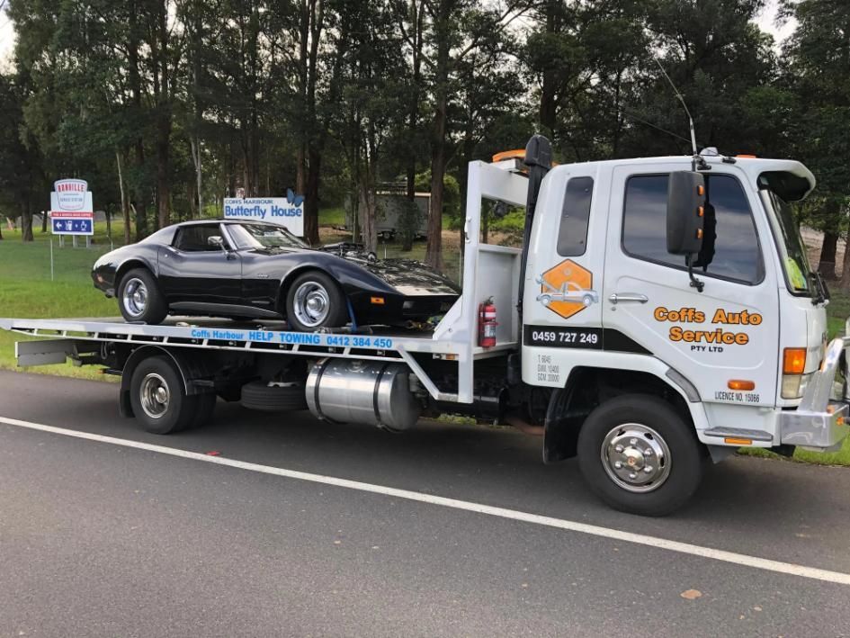 A Tow Truck is Carrying a Corvette on the Back of It — Coffs Tow Trucks In North Boambee Valley, NSW