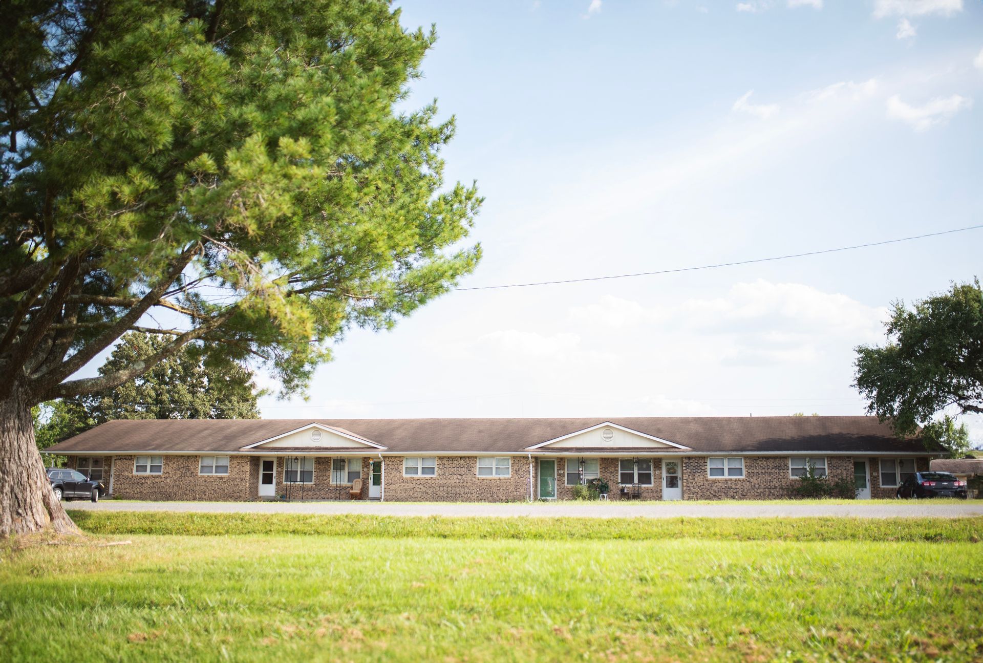 A large brick building with a tree in front of it.