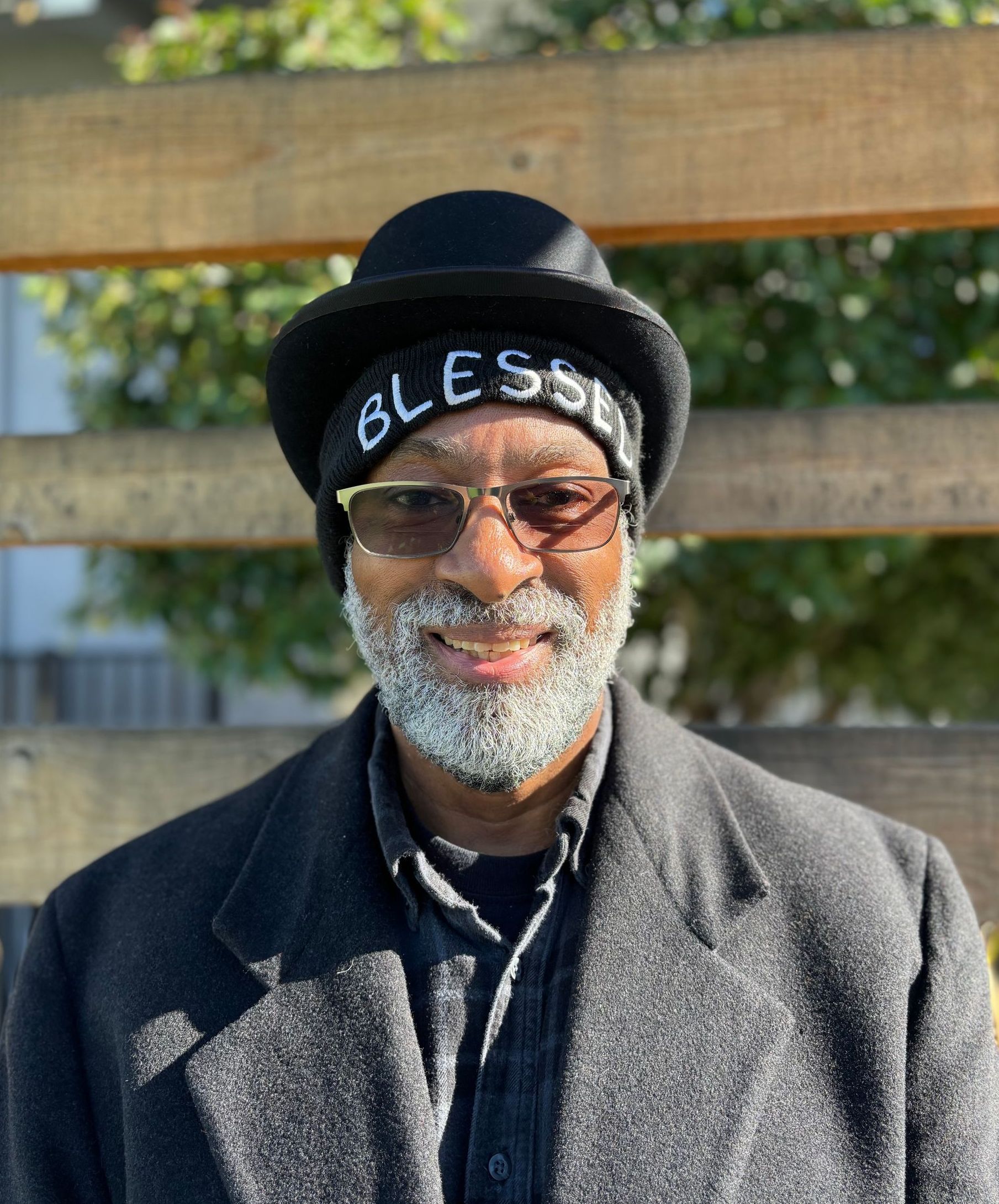 A man with a beard is wearing a hat and glasses.