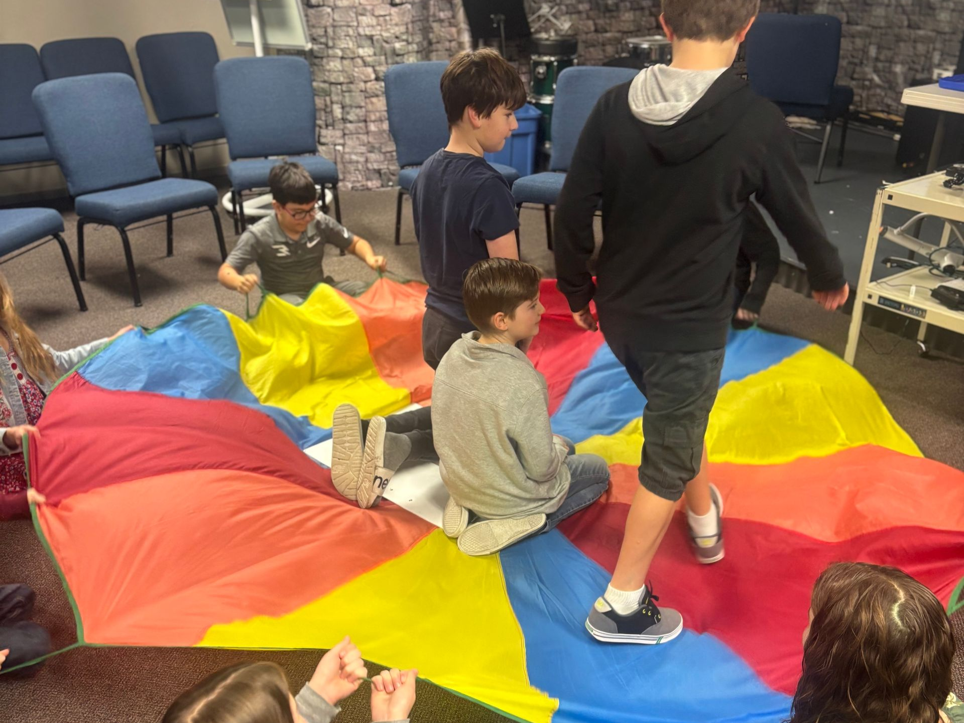 A group of children are sitting in a circle in a room.